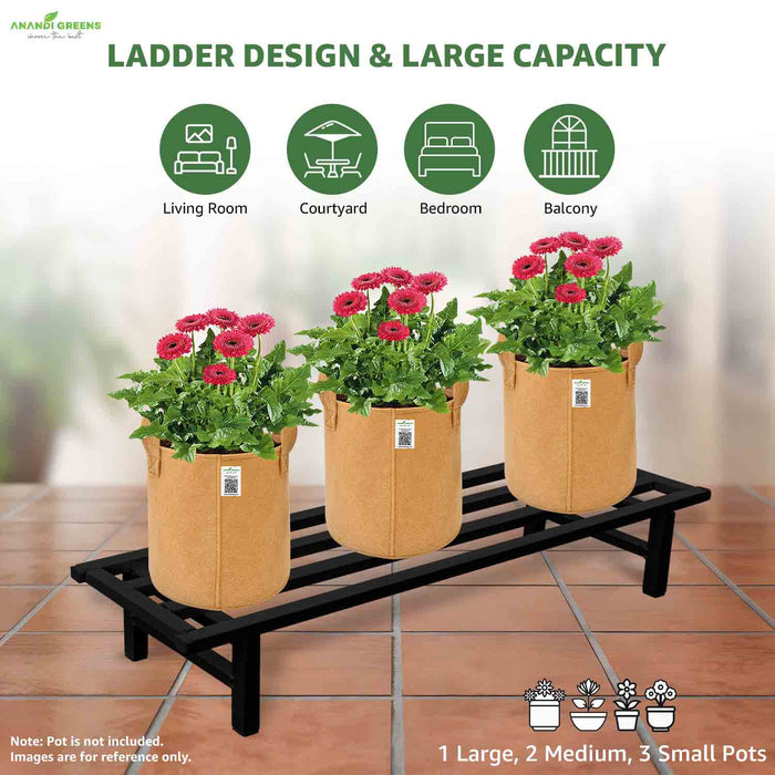 Black ladder plant stand with tan pots containing flowers on a tiled floor.